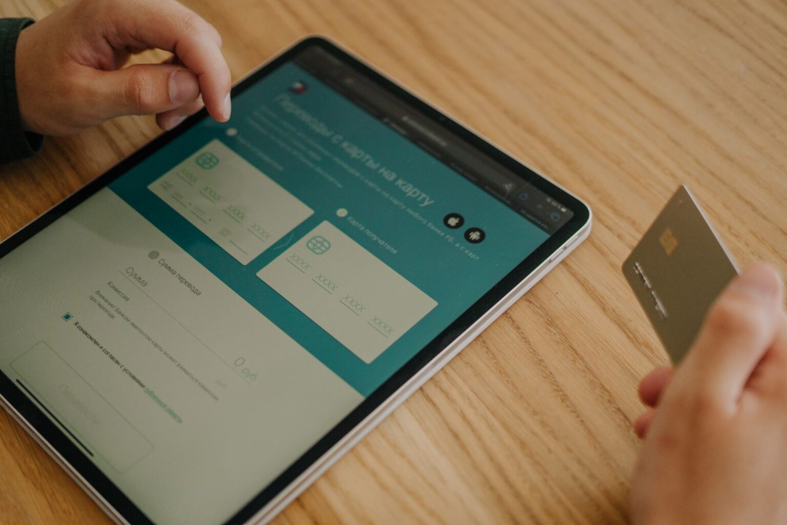 Jak kupować rozsądnie i nie przepłacać? Praktyczny przewodnik po codziennych zakupach Hands making an online purchase using a tablet and credit card on a wooden table.